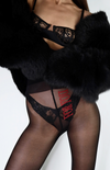 Crafted from sustainable yarns in Italy—Thunderstorm tights feature sheer black fabric with red embroidered thunderbolts.