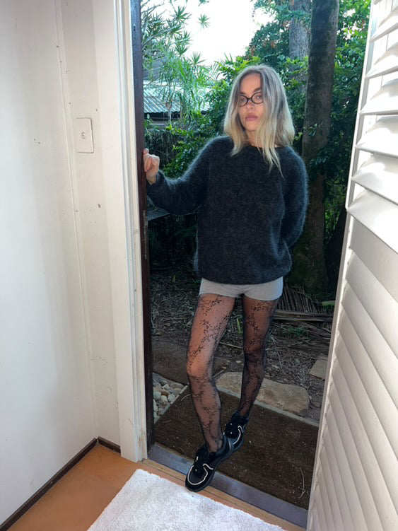 Forever Fishnet tights styled casually with micro-shorts and sneakers—Italian-made statement fishnets for effortless off-duty looks.