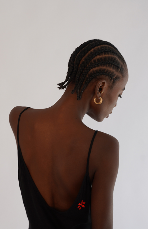 Close-up of red floral embroidery and 'Take Me Off' message placed along the body’s sensual lines