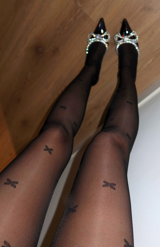 Sheer black tights with stars styled for a night out with heels and a party dress
